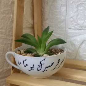 قوار على شكل فنجان بعبارة ( سيزهر صبرك يومًا ما )